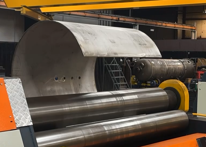 See stainless steel being rolled into a cylinder for a pressure vessel